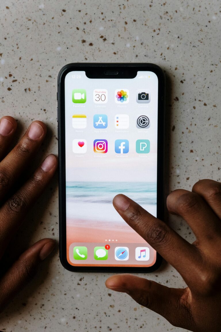 Hands interacting with smartphone apps on a table. facebook ads