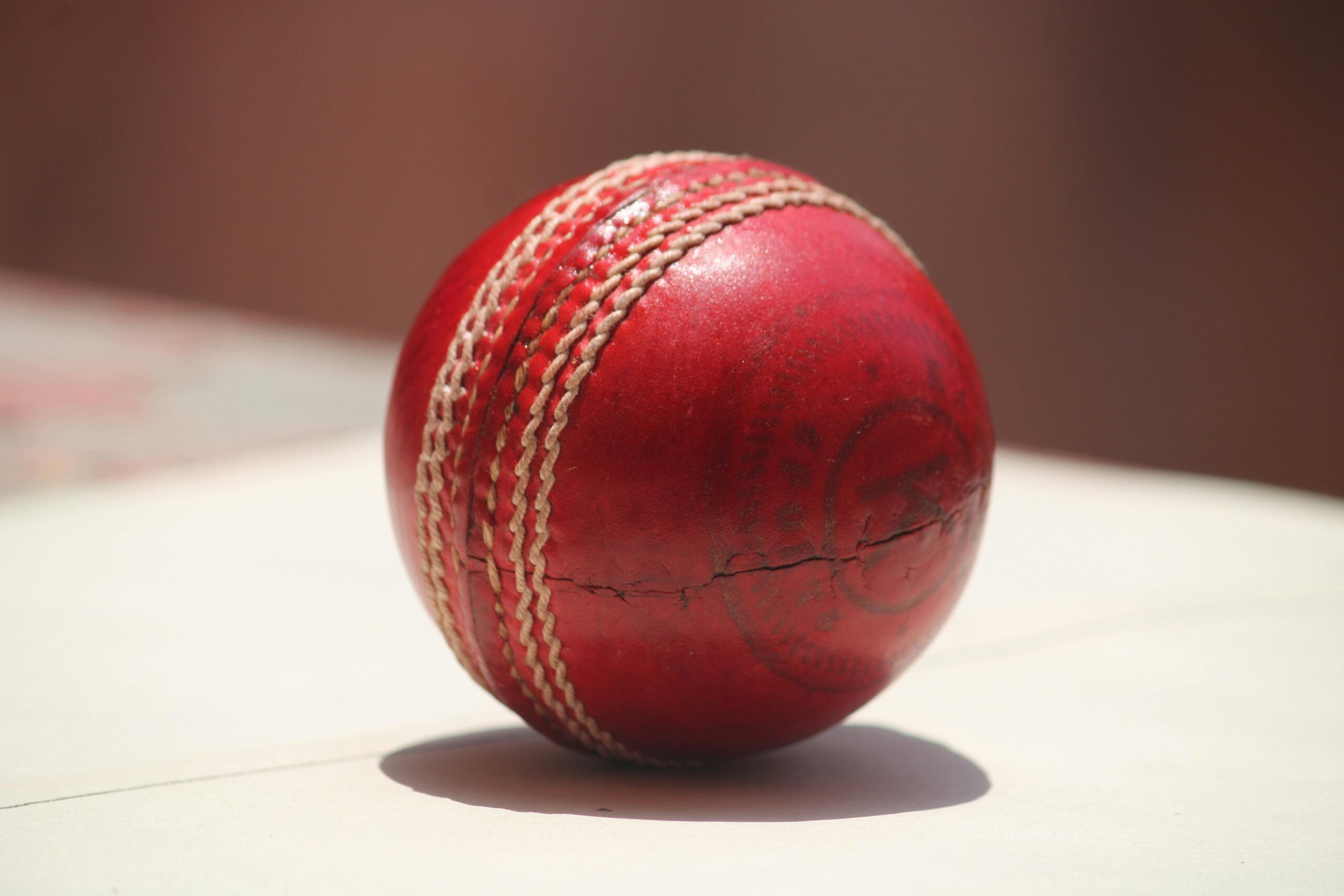 punjab kings vs royal challengers bengaluru match scorecard 2 Detailed close-up of a red leather cricket ball showing wear and stitching. punjab kings vs royal challengers bengaluru match scorecard