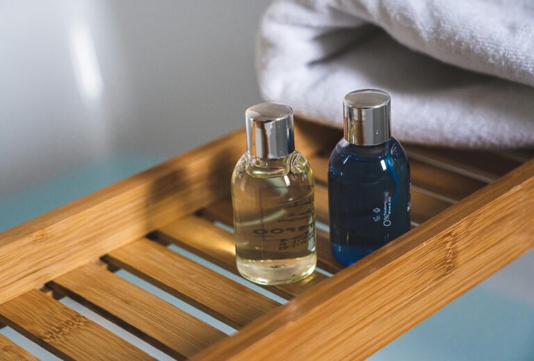 Two elegant toiletries bottles on a bamboo tray in a serene bathroom setting.Salon Salon